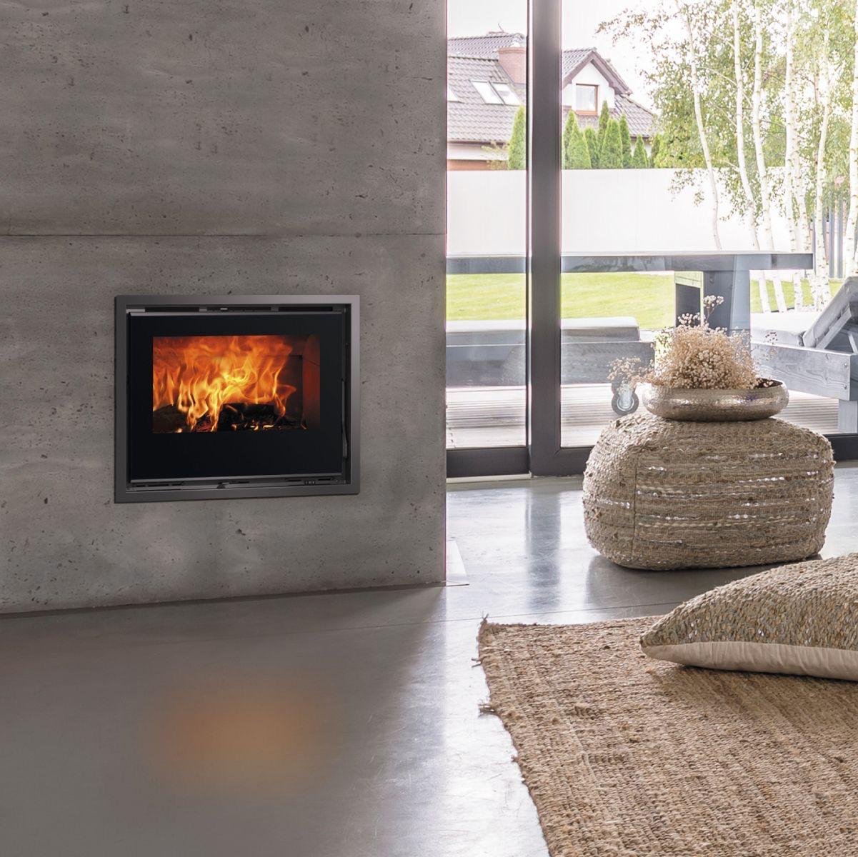 Built-in slow-combustion fireplace burning in a concrete wall installation