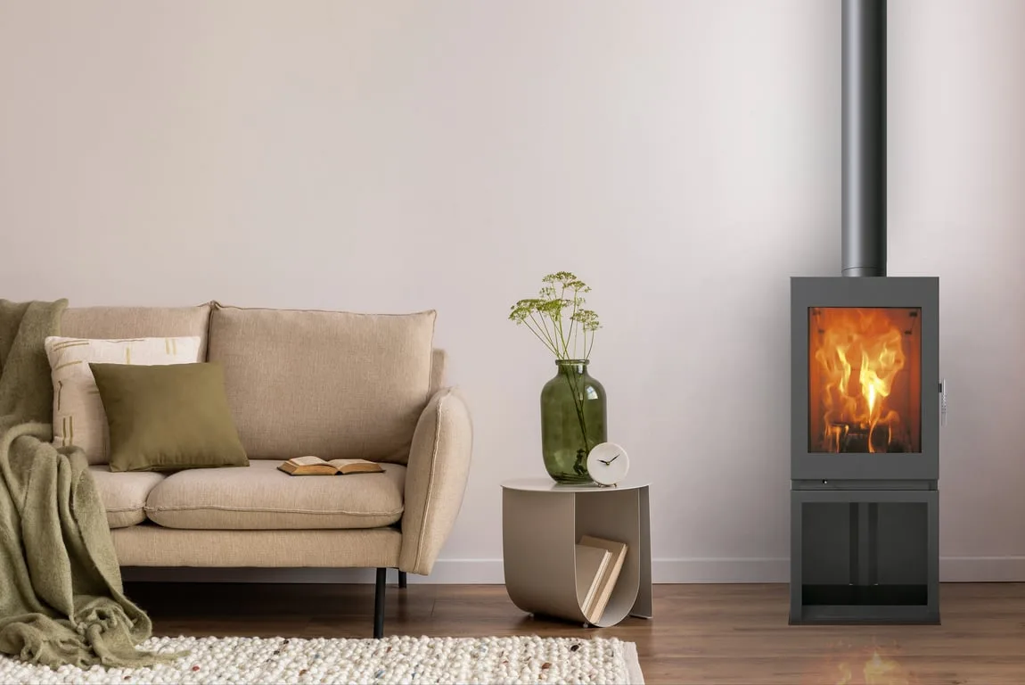 Freestanding slow-combustion fireplace burning in a living room