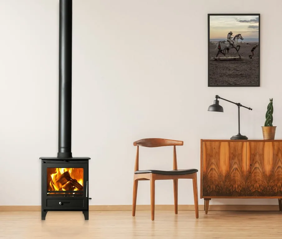 Installed slow combustion fireplace with visible black flue rising from the appliance