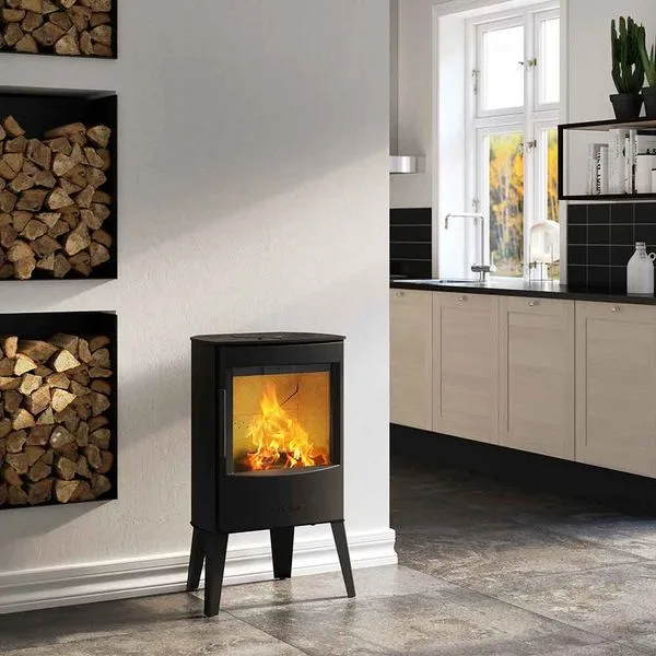 Wiking Mini 2 freestanding fireplace beside stacked firewood